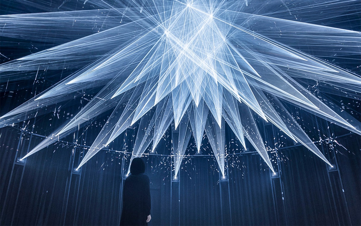 Visitor observing light installation at teamLab SuperNature in Macau.