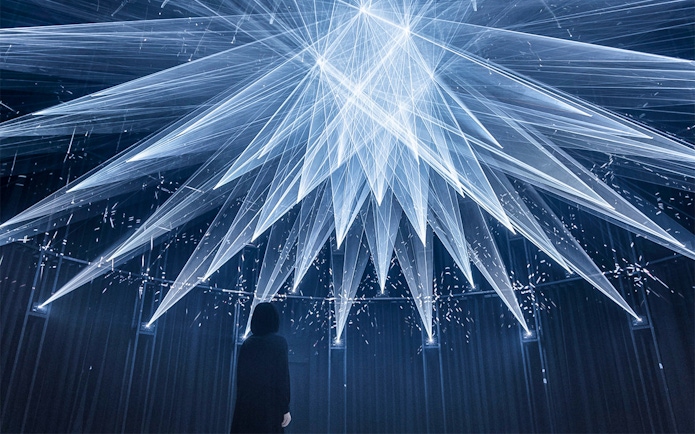 Visitor observing light installation at teamLab SuperNature in Macau.