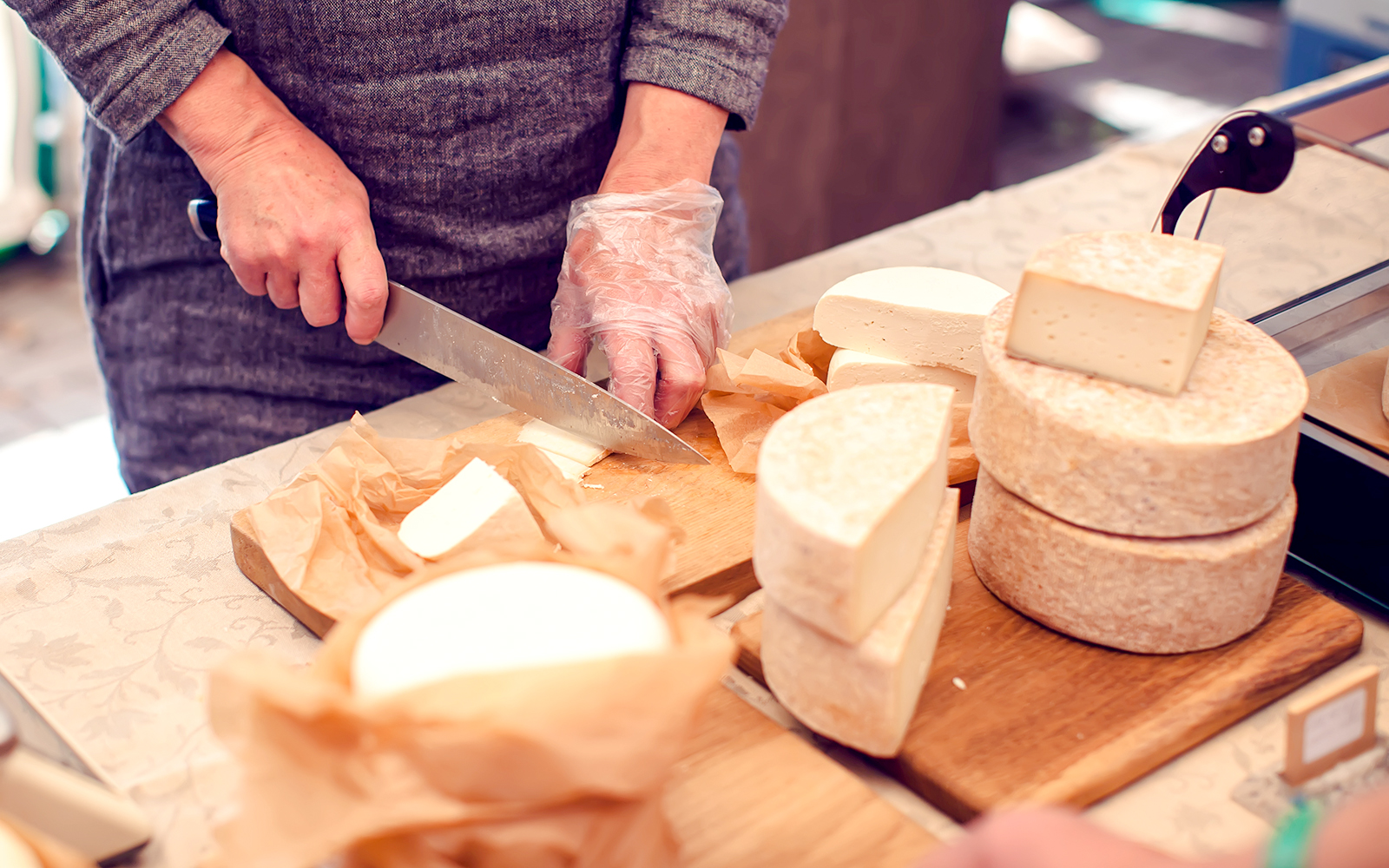 Chef slicing cheese at Cheese Museum in Paris.