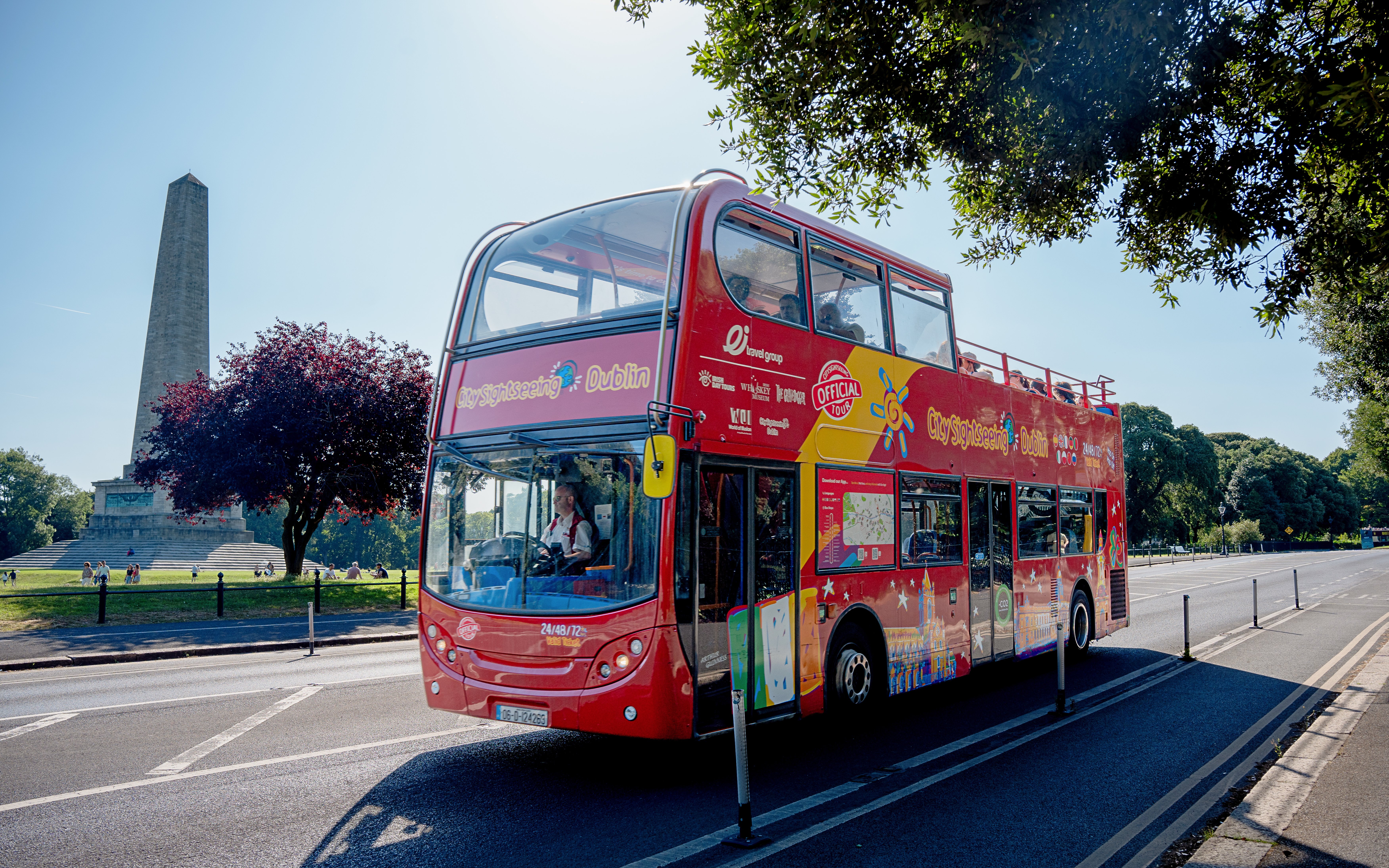 Open-top tour bus in Dublin passing the Wellington Monument in Phoenix Park.