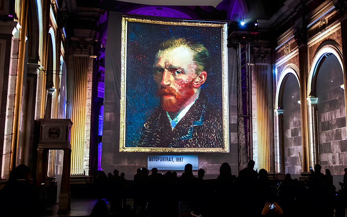 Van Gogh self-portrait displayed at London exhibition with guests viewing.