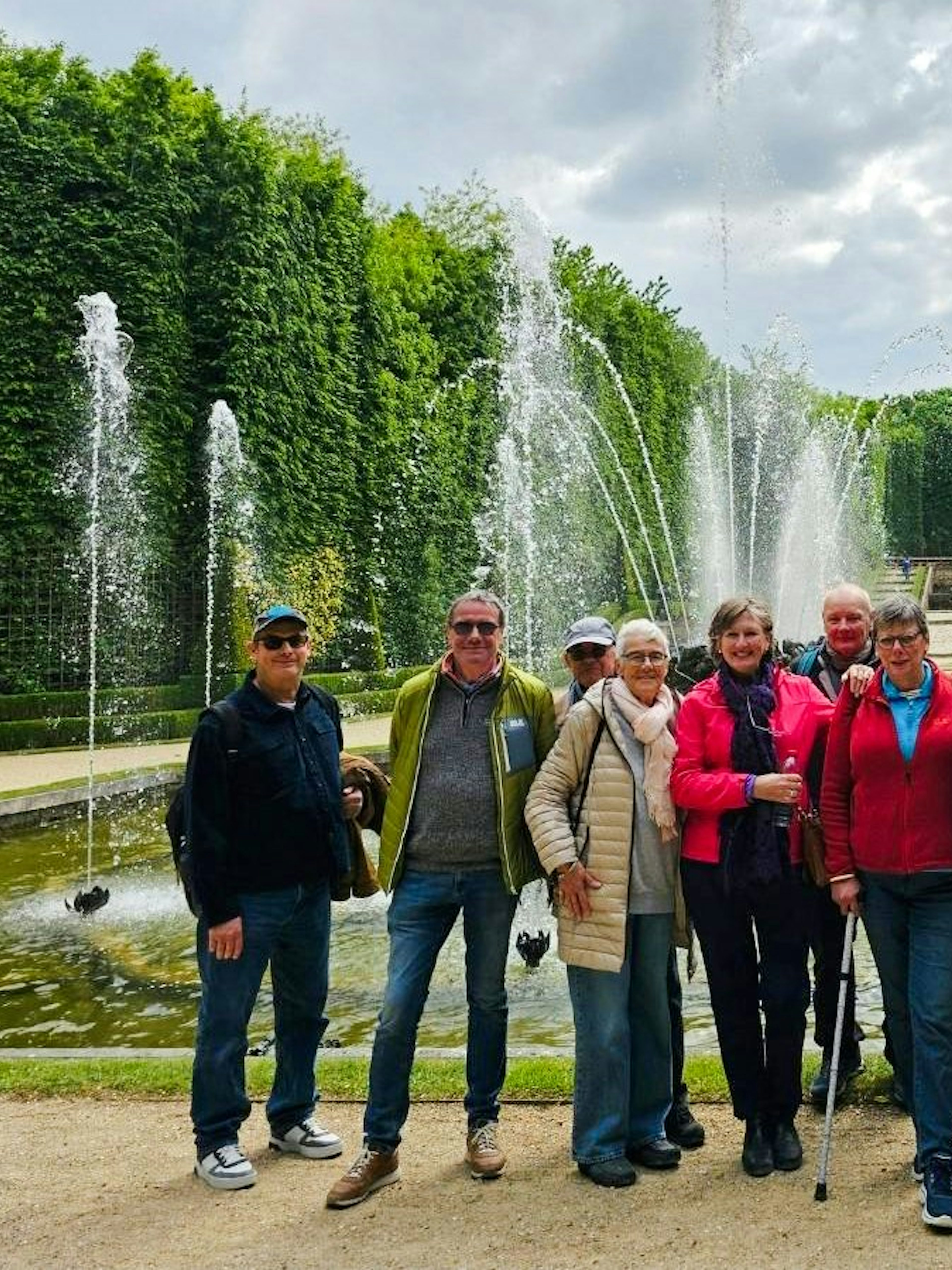 Group enjoying Versailles guided tour by fountains.