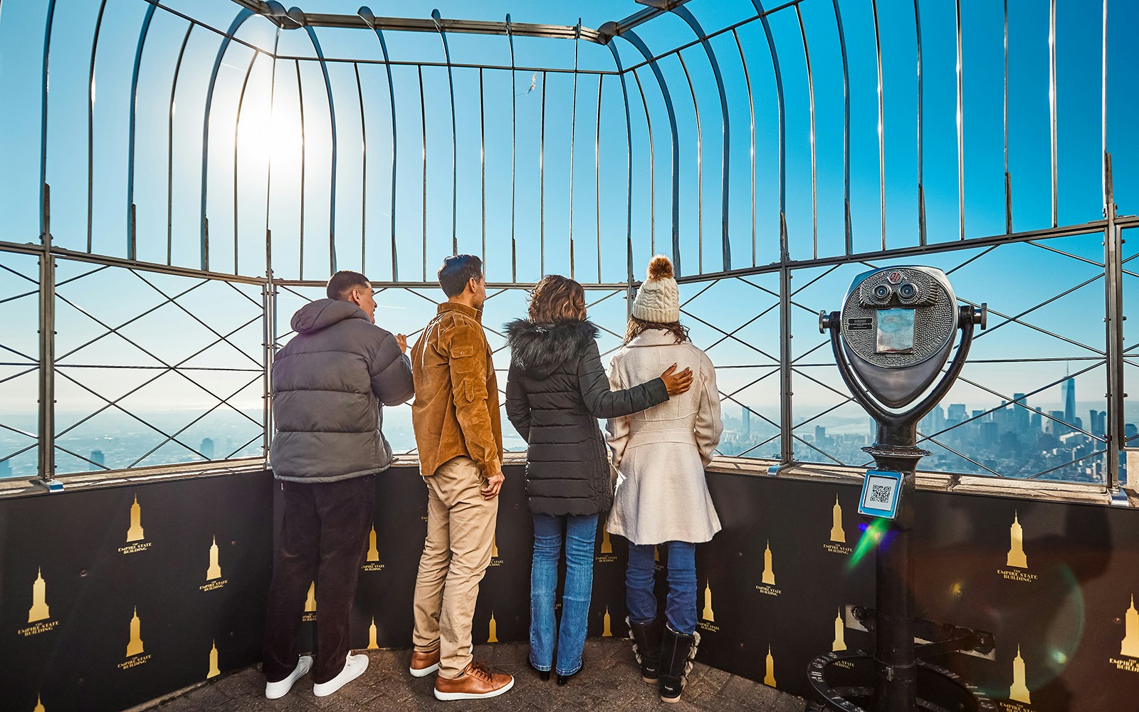 Visitors on the Empire State Building's observation deck enjoying New York City views.