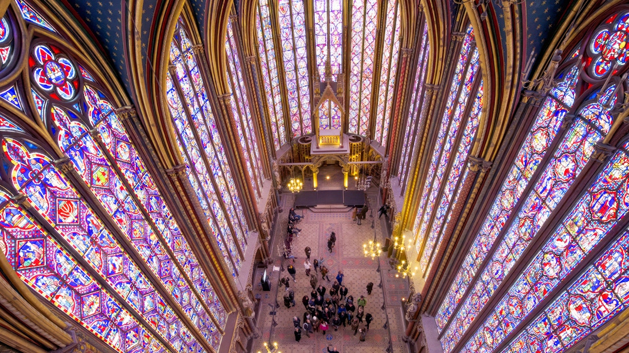 Gothic architecture of Saint Chapelle, featuring intricate stained glass windows, located in Paris, France, on a guided tour