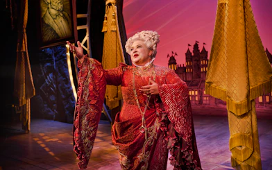Performer in ornate costume on stage during Wicked musical.