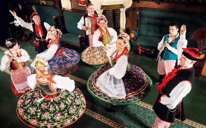 Folk dancers in traditional Polish costumes performing at Jama Michalika Cafe.