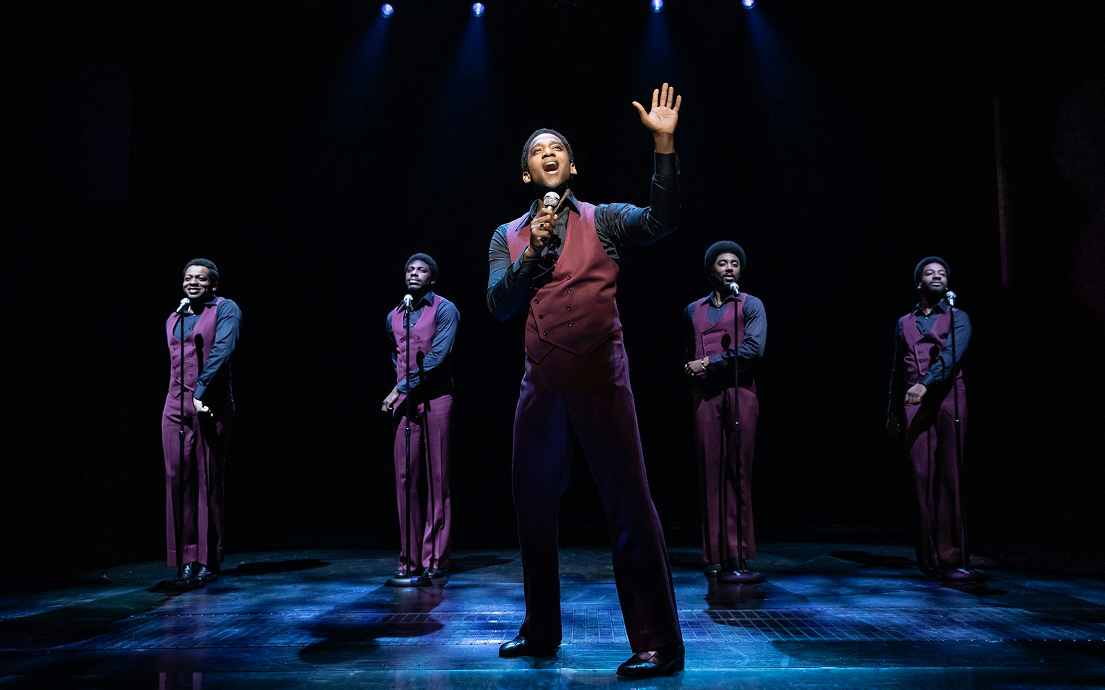 Performers singing on stage in "Ain't Too Proud" musical.