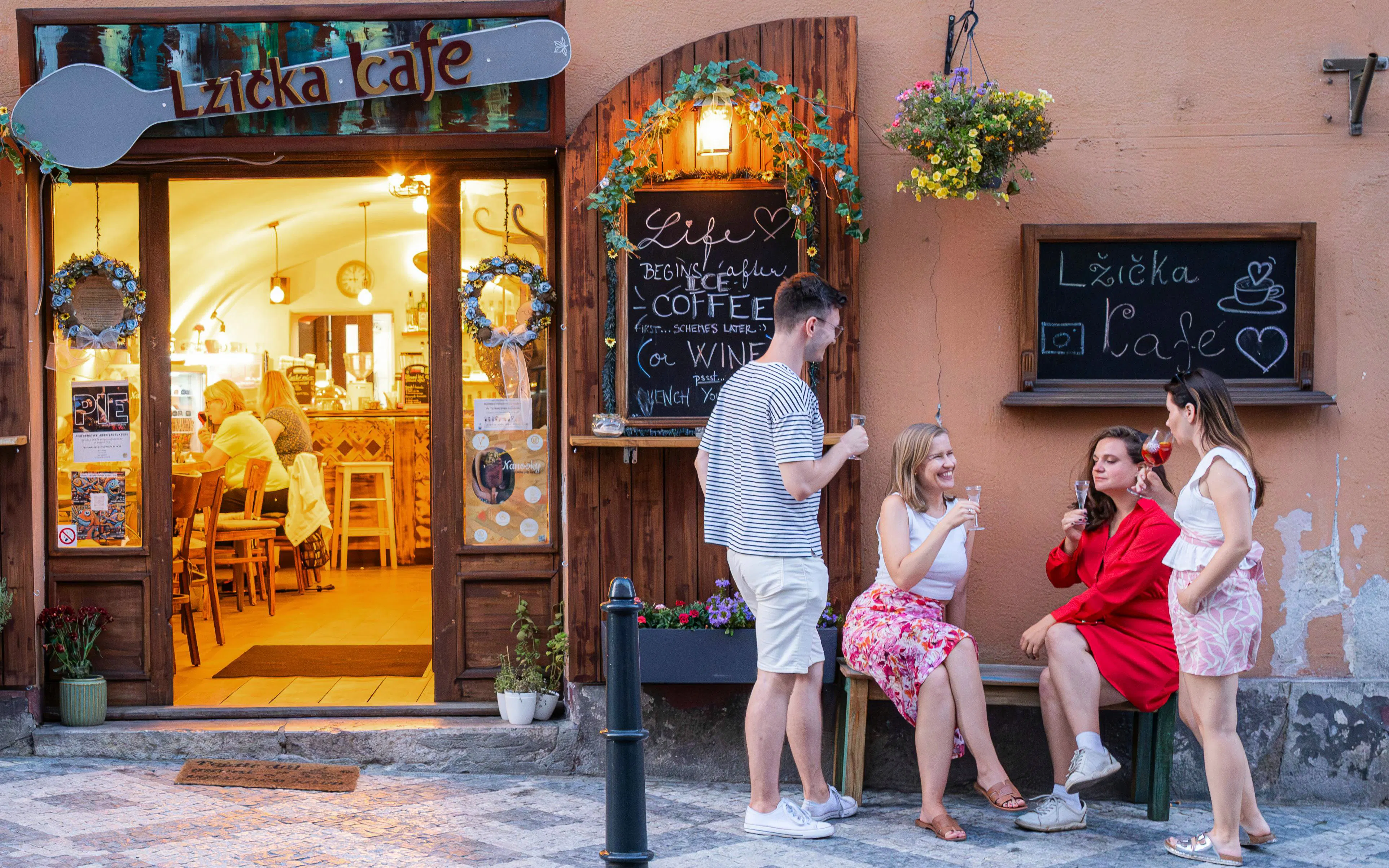 Small group enjoying drinks outside Lzicka Cafe, Prague Old Town.