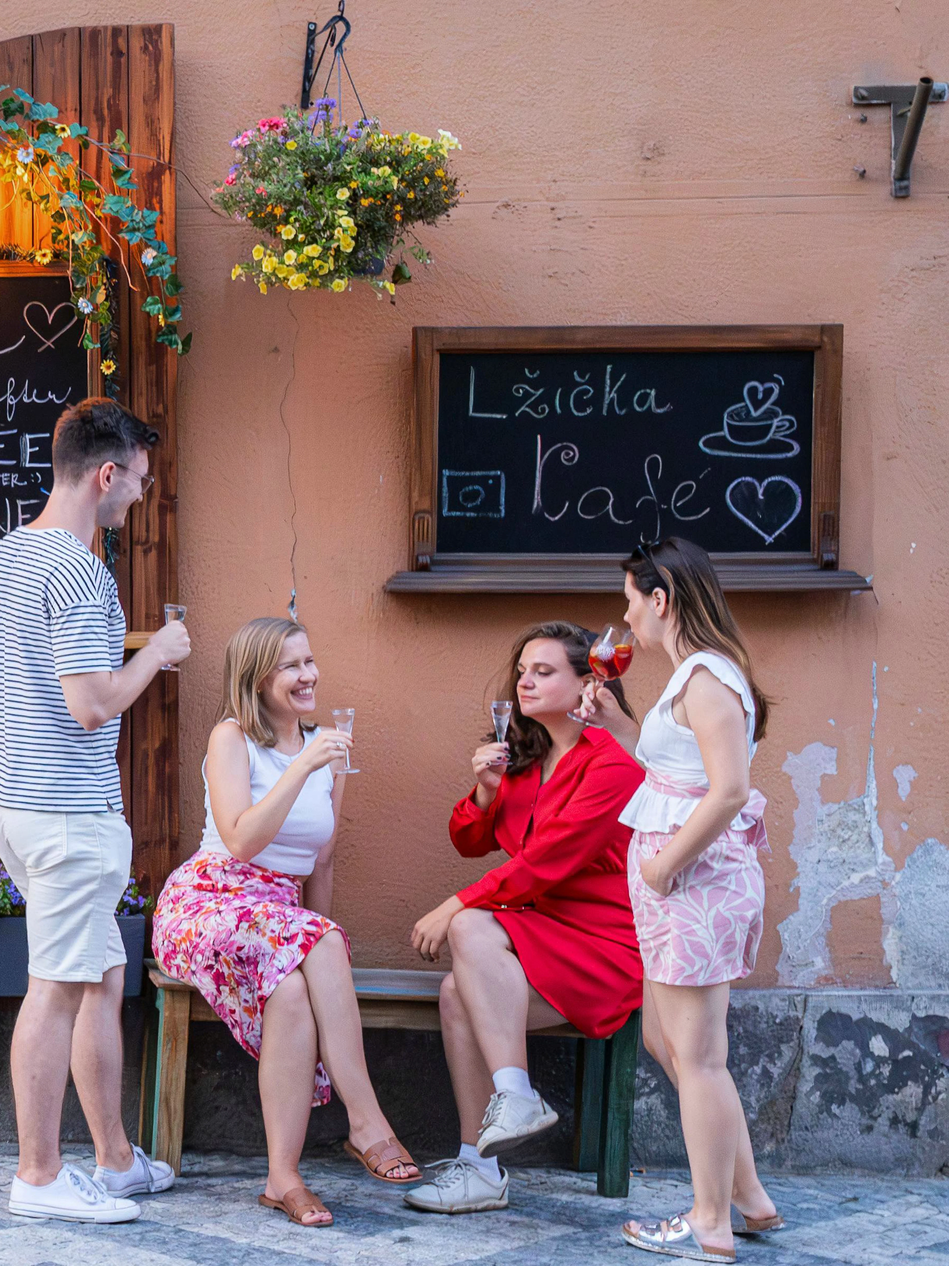 Small group enjoying drinks outside Lzicka Cafe, Prague Old Town.