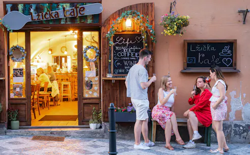 Small group enjoying drinks outside Lzicka Cafe, Prague Old Town.