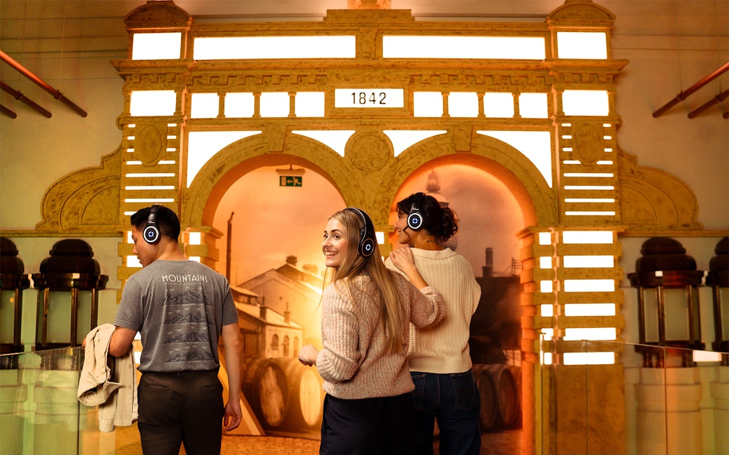 Visitors with headphones explore Prague Pilsner Urquell Experience exhibit.
