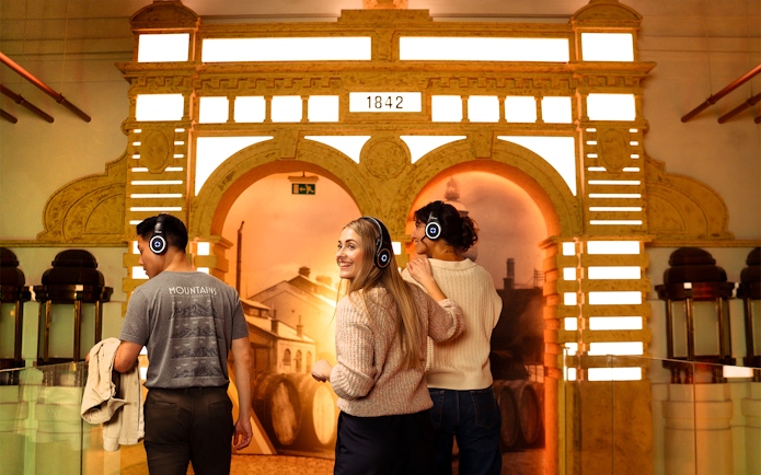 Visitors with headphones explore Prague Pilsner Urquell Experience exhibit.
