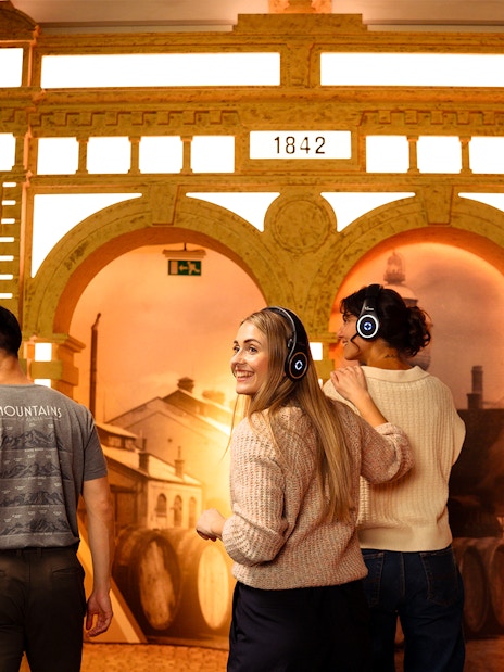 Visitors with headphones explore Prague Pilsner Urquell Experience exhibit.