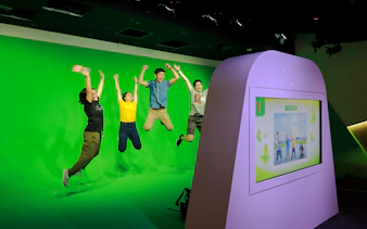 Visitors jumping in front of a green screen at Changi Experience Studio interactive exhibit.
