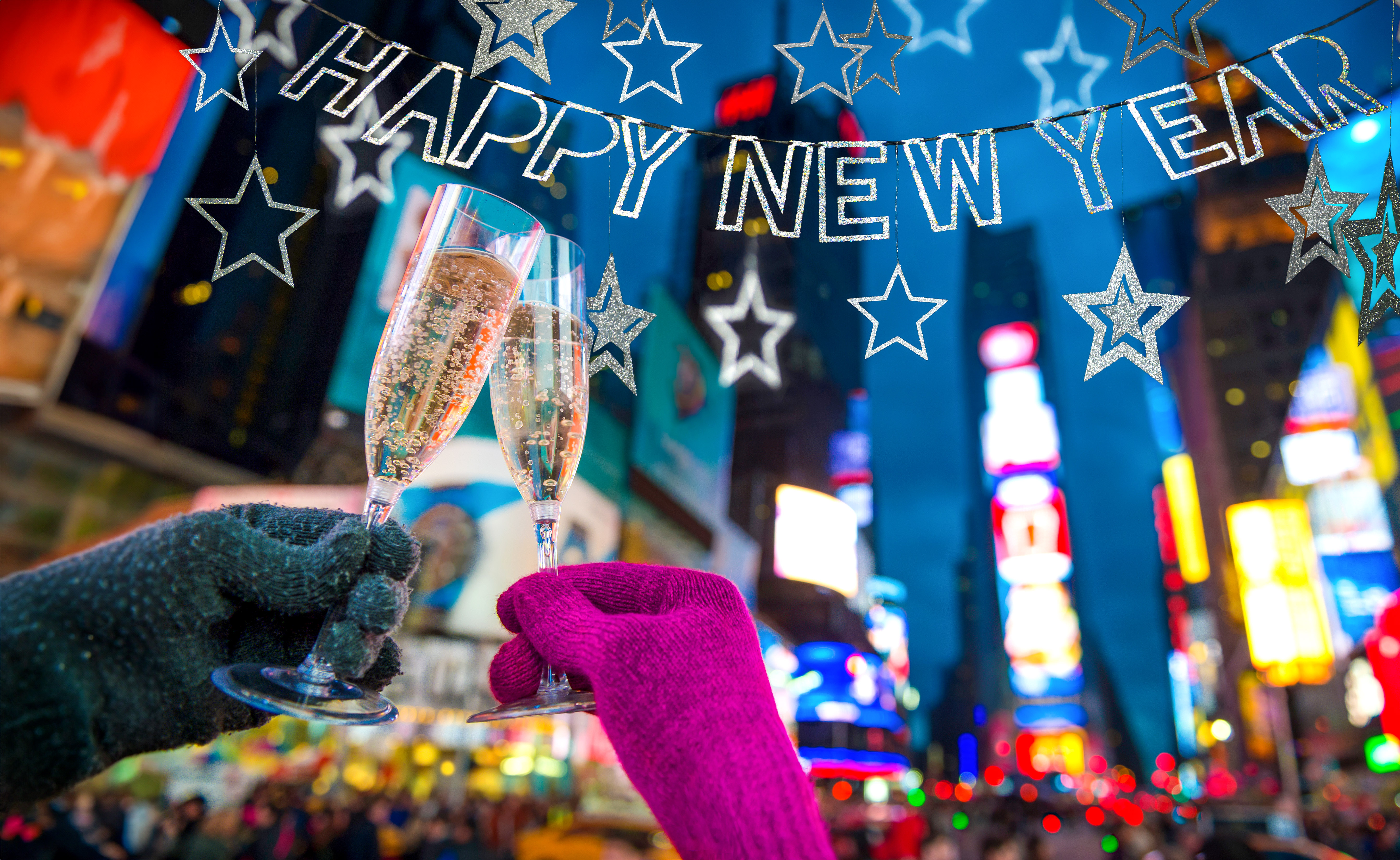 Champagne toast under "Happy New Year" sign at Times Square, New York City.