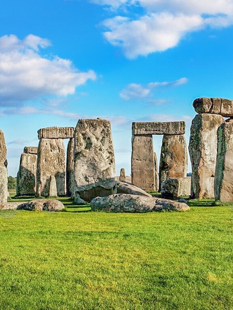 Stonehenge stone circle under blue sky on a day trip from London.