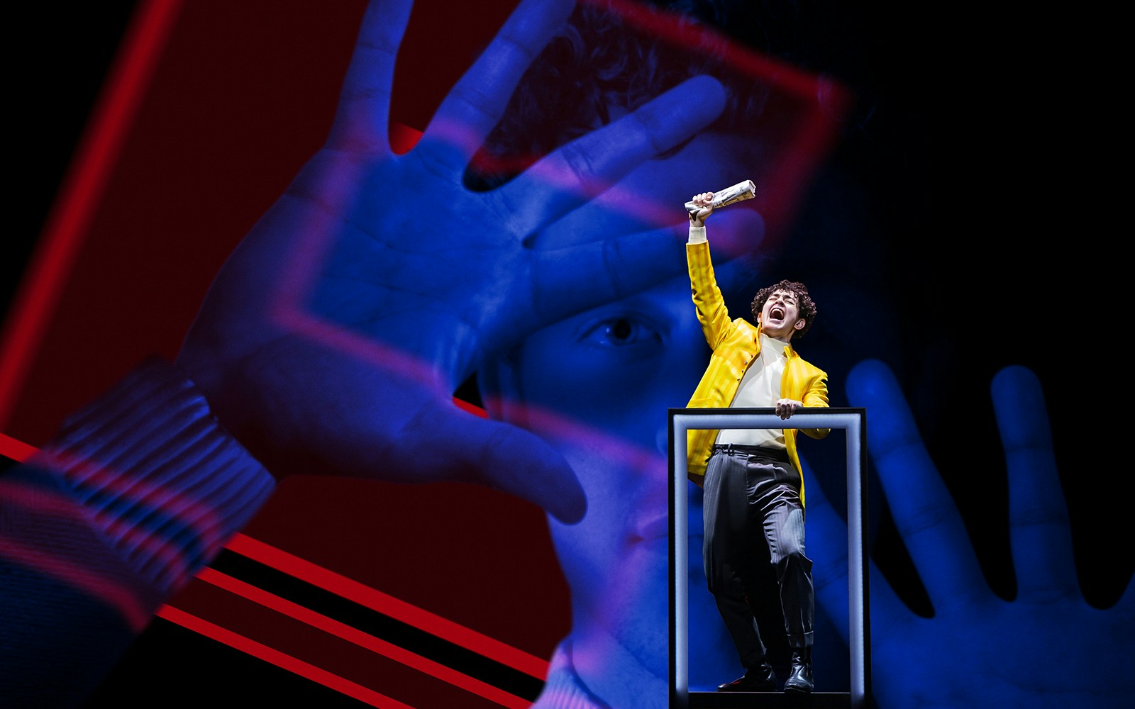 Performer in yellow jacket on stage during The Who's Tommy musical.