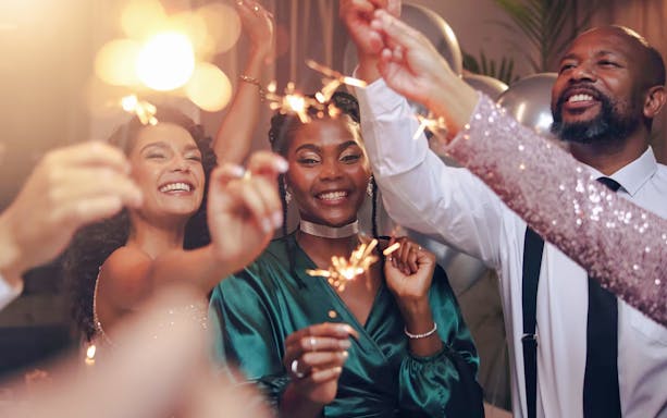 Tourists celebrating with sparklers at a lively party.