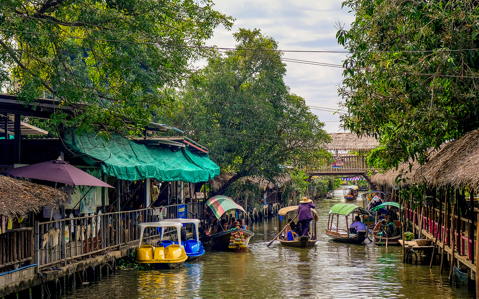 Boats navigating the canal at Khlong Lat Mayom Floating Market, Bangkok.