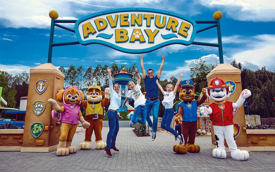 Visitors jumping with joy at Adventure Bay entrance, Bottrop Movie Park, Germany.