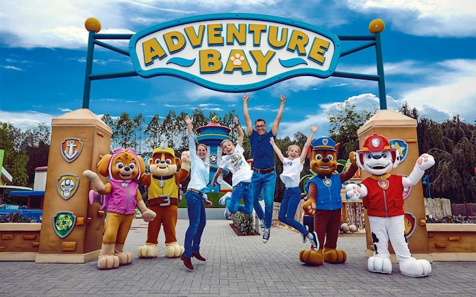 Visitors jumping with joy at Adventure Bay entrance, Bottrop Movie Park, Germany.