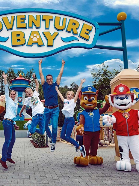 Visitors jumping with joy at Adventure Bay entrance, Bottrop Movie Park, Germany.