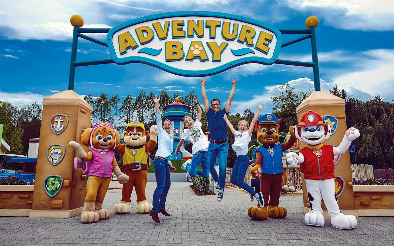 Visitors jumping with joy at Adventure Bay entrance, Bottrop Movie Park, Germany.