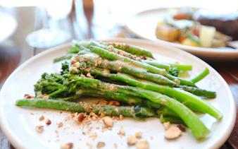 Steamed broccolini with nuts served on a plate during Sydney Harbour cruise buffet dinner.