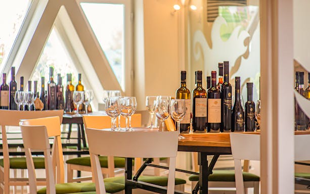 Wine bottles and glasses on a table in a Santorini tasting room.