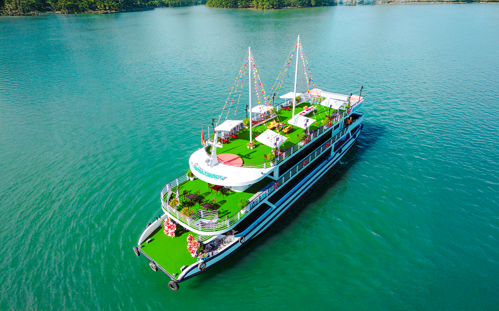Luxury Sky Apollo Cruise 2 on turquoise water with green deck and festive decorations.