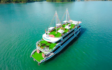 Luxury Sky Apollo Cruise 2 on turquoise water with green deck and festive decorations.