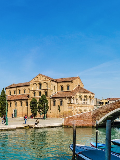 Murano Basilica dei Santi Maria e Donato with canal and boats in foreground.