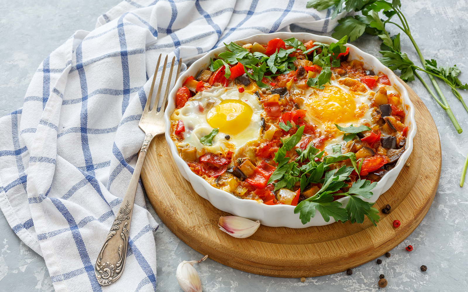 Spicy shakshuka with eggs, eggplant and tomatoes.