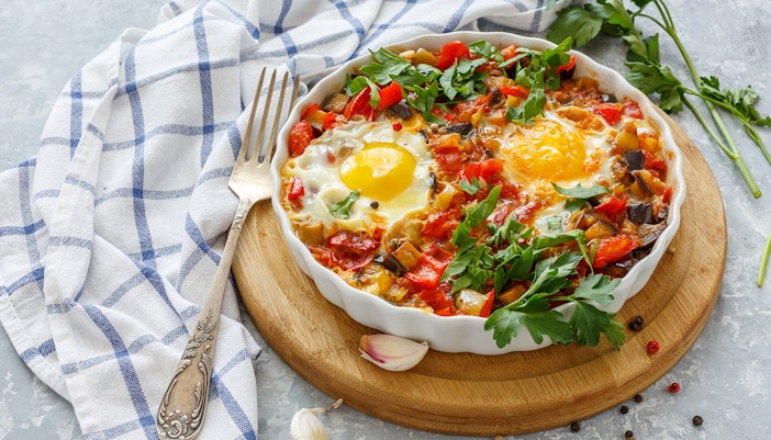 Spicy shakshuka with eggs, eggplant and tomatoes.