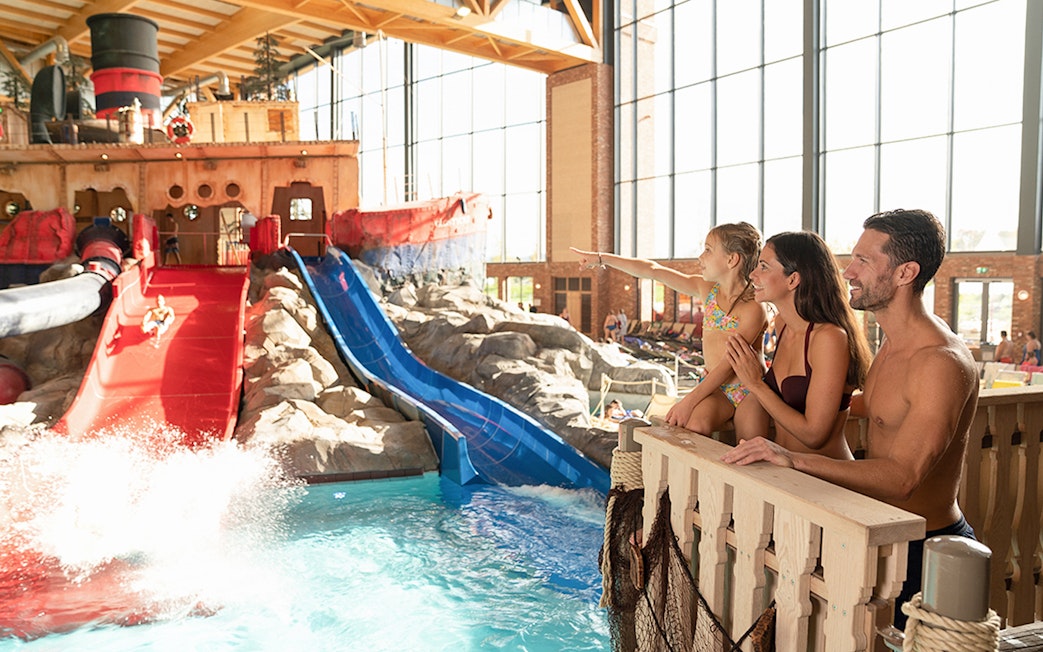 Family enjoying water slides at Rulantica indoor water park.