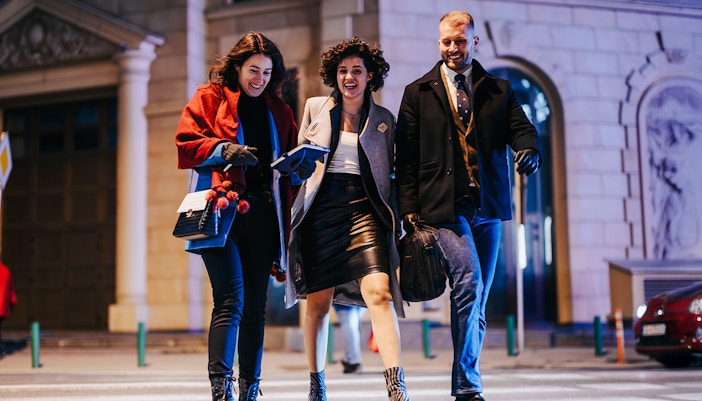Group enjoying a night walking tour in a city street.