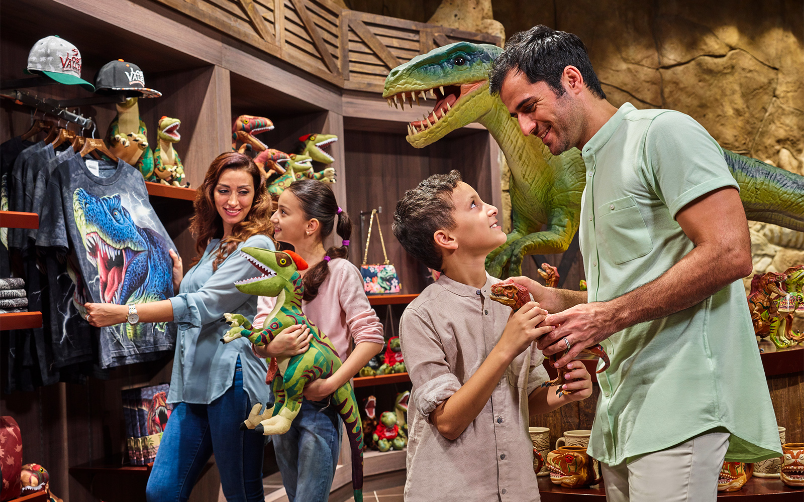 Family shopping for dinosaur toys at IMG Worlds of Adventure gift shop.