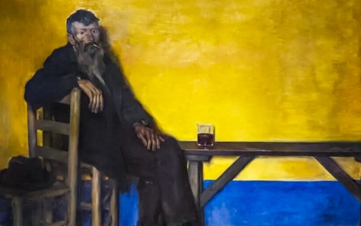 Man sitting on a chair with a drink on a table, Modernism Museum Barcelona.