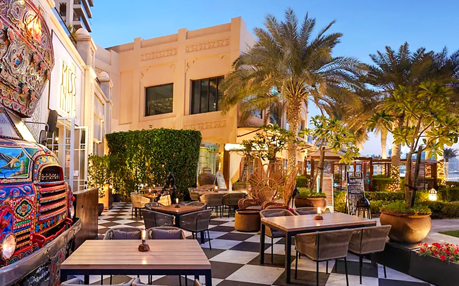 Outdoor dining area at Fairmont Hotel with palm trees and decorative truck.