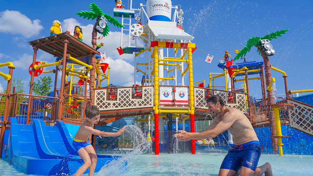 Parent and child playing in water at Legoland Waterpark.
