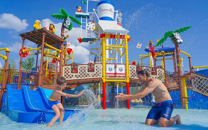Parent and child playing in water at Legoland Waterpark, Gardaland.