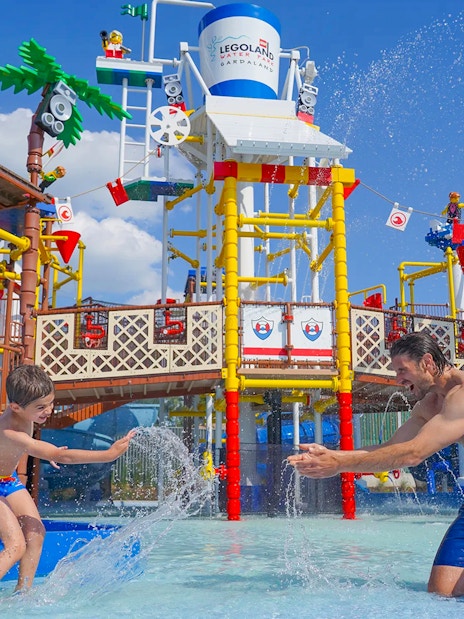 Parent and child playing in water at Legoland Waterpark, Gardaland.