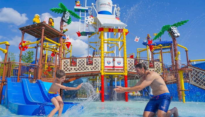 Parent and child playing in water at Legoland Waterpark, Gardaland.