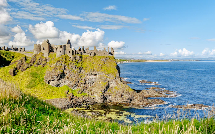 Dunluce Castle ruins on a cliff overlooking the North Atlantic Ocean in Northern Ireland.