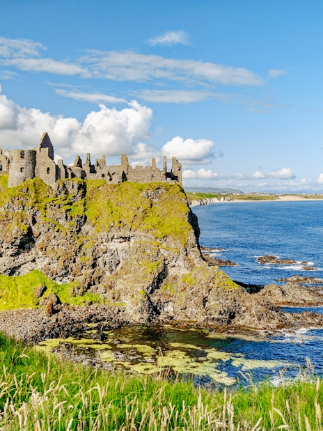 Dunluce Castle ruins on a cliff overlooking the North Atlantic Ocean in Northern Ireland.