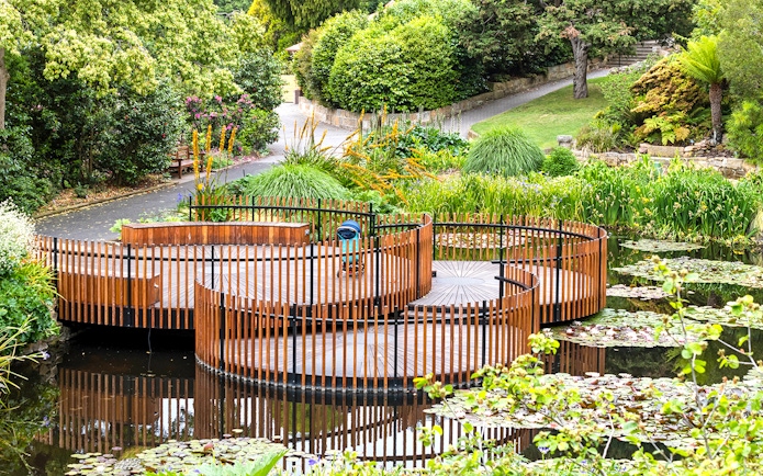 Circular wooden walkway in a lush garden, part of Hobart city tour.