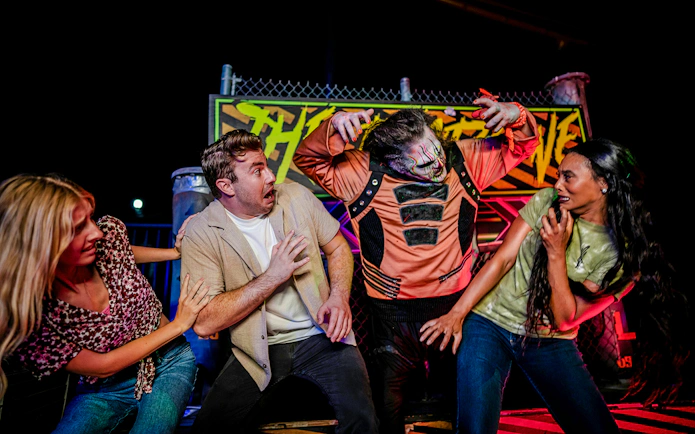 Guests reacting to a costumed performer in Halloween Haunt zone at Dorney Park.