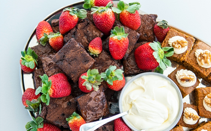 Brownies and strawberries with cream on a platter for Murray River Lunch Cruise.