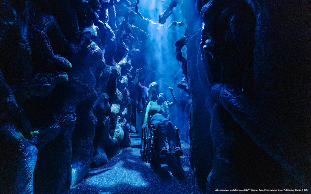 People exploring a magical maze with wands, part of the Harry Potter Visions of Magic tour.