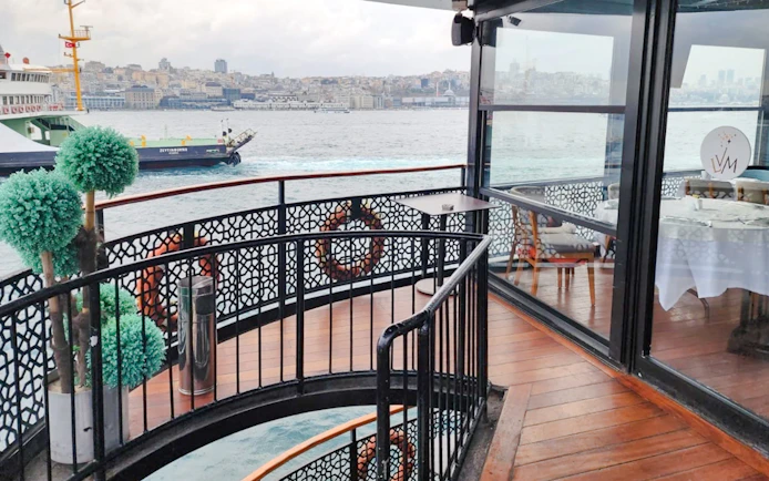 Deck view of Le Vapeur Magique on Bosphorus Cruise with cityscape in the background.